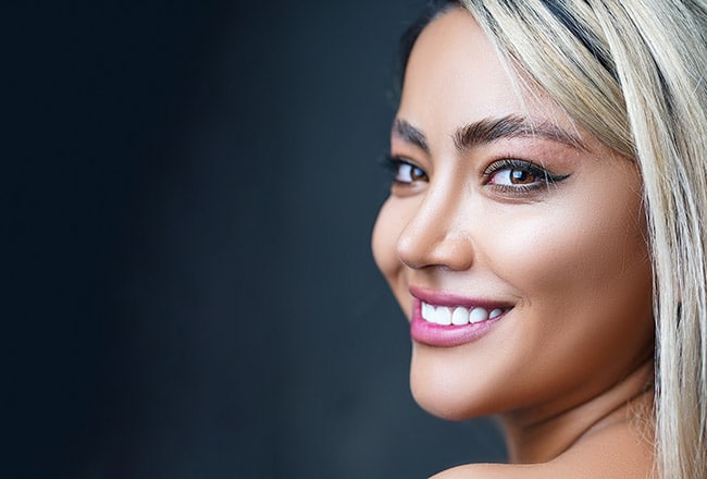 Lady smiling confidently after Teeth Whitening treatment, showcasing bright and radiant teeth